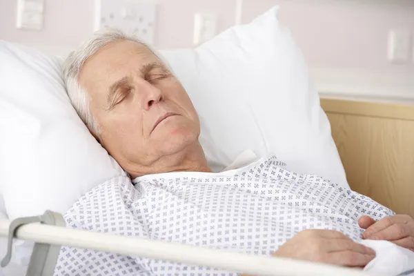 Senior man asleep in hospital bed — Stock Photo, Image