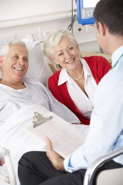 Врач разговаривает со старшей парой в больнице Великобритании — стоковое фото