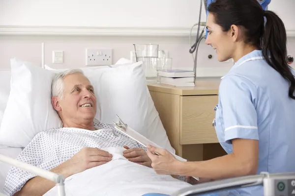 Verpleegkundige en mannelijke patiënt in uk ongevallen en noodsituaties — Stockfoto