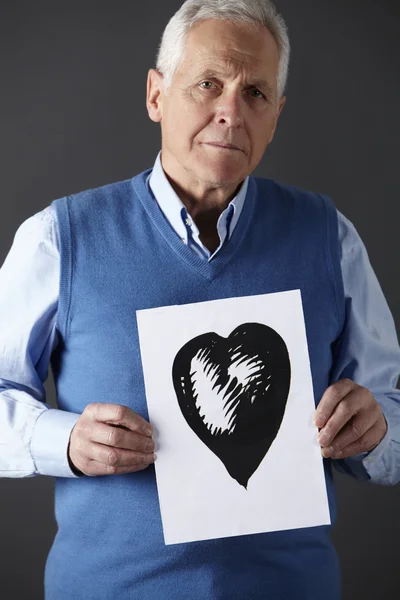 Hombre mayor sosteniendo tinta dibujo de corazón —  Fotos de Stock
