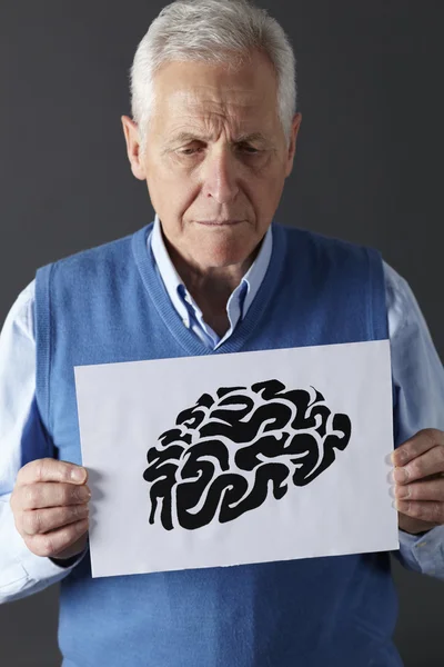 Homem sênior segurando desenho de tinta do cérebro — Fotografia de Stock