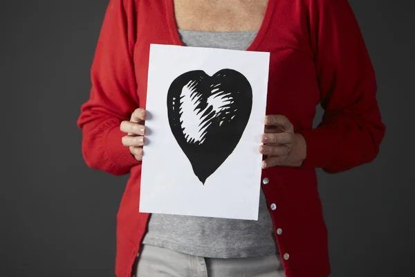Senior woman holding ink drawing of heart — Stock Photo, Image
