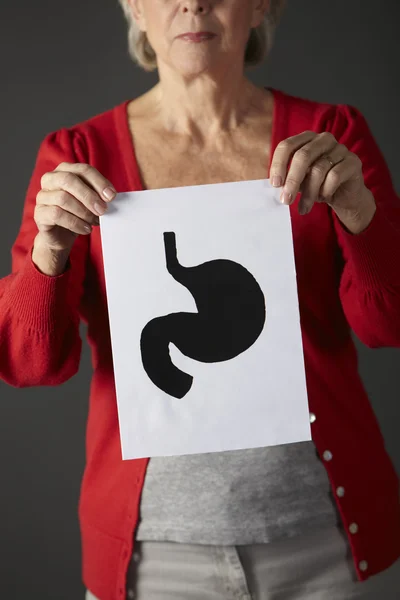 Senior woman holding ink drawing of stomach — Stock Photo, Image