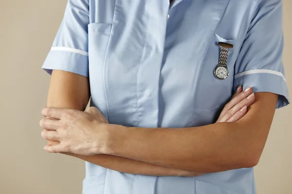 Enfermeira britânica de pé com os braços dobrados — Fotografia de Stock
