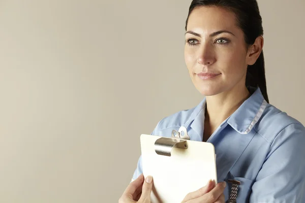 Enfermera del Reino Unido sujetando portapapeles — Foto de Stock