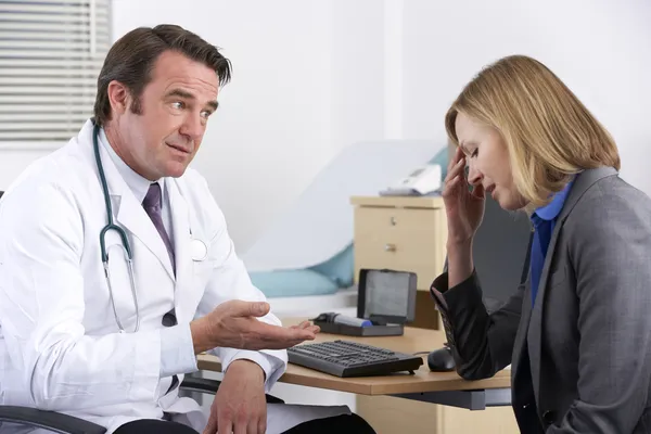 Médico americano hablando con una mujer de negocios deprimida — Foto de Stock