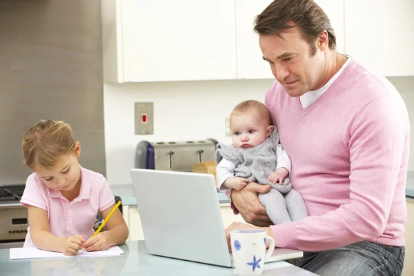 Padre con niños usando el ordenador portátil en la cocina — Foto de Stock