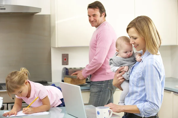 Familjen upptagen tillsammans i köket — Stockfoto