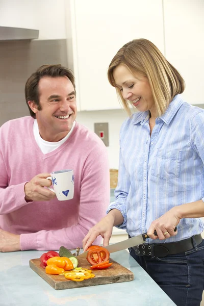 Mature couple preparing meal in domestic kitchen — Stock Photo, Image