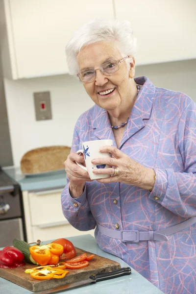 Femme âgée préparant la nourriture dans la cuisine domestique — Photo