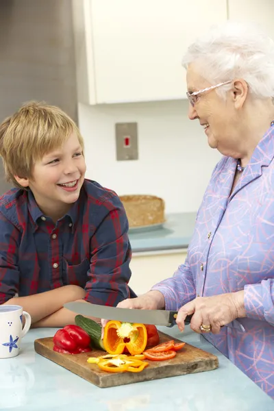 Бабушка и внук готовят еду на кухне — стоковое фото