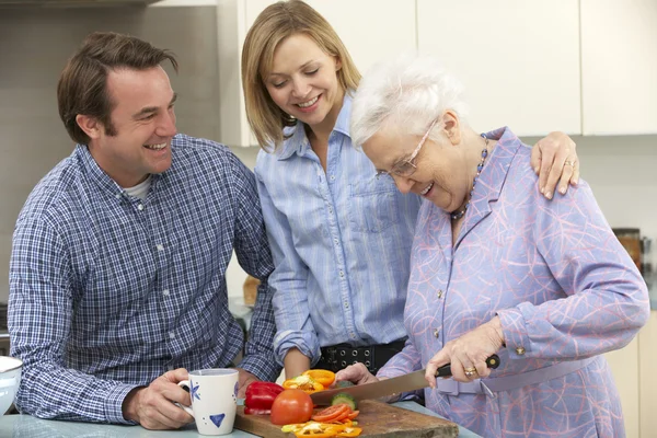 Femme âgée et famille préparant le repas ensemble — Photo