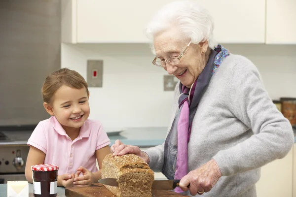 Nagymama és unokája étel a konyhában — Stock Fotó
