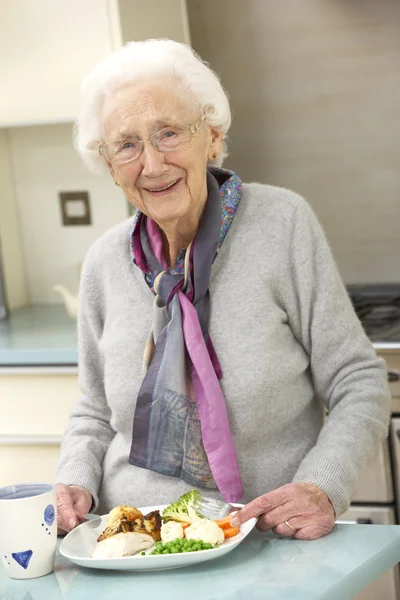 Donna anziana che si gode il pasto in cucina — Foto Stock
