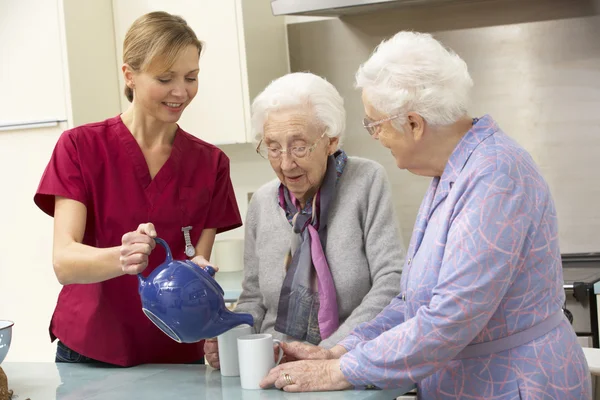 Mujeres mayores en casa con cuidador —  Fotos de Stock