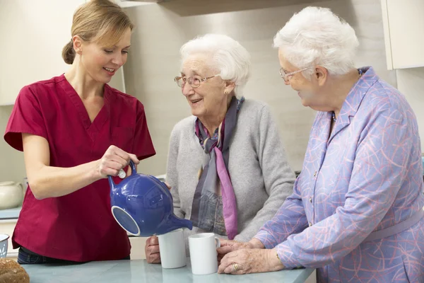 Mujeres mayores en casa con cuidador —  Fotos de Stock