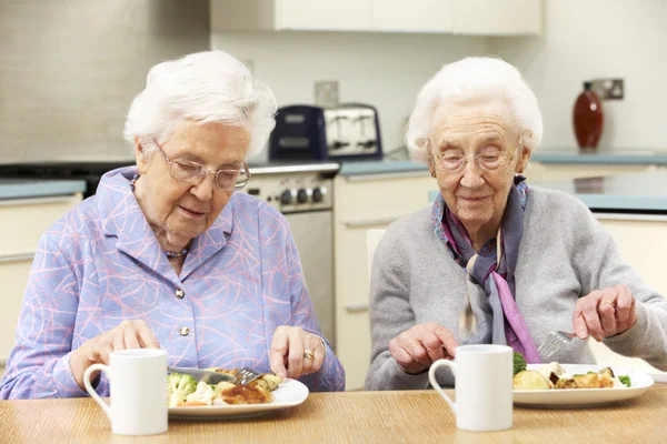 Femmes âgées dégustant un repas ensemble à la maison — Photo