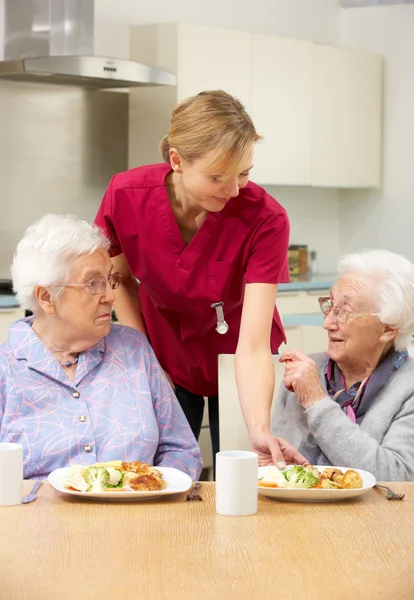 Starszych kobiet z opiekunem posiłku w domu — Zdjęcie stockowe