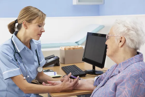 Enfermeira do Reino Unido a injectar doente idoso — Fotografia de Stock