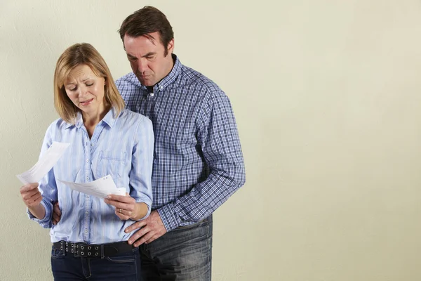 Studio Shot Of Middle Aged Couple Looking at Bills — Stock Photo, Image