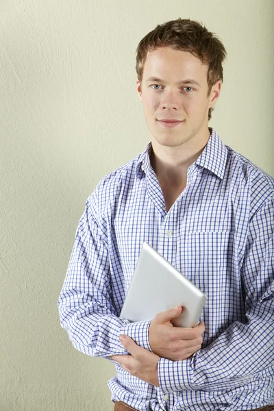 Studio záběr mladého muže drží tabletový počítač — Stock fotografie