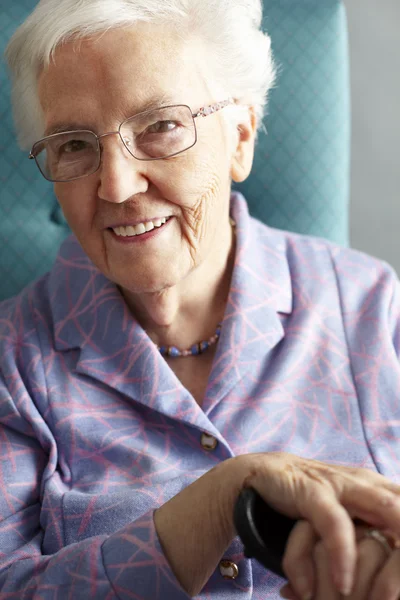 Äldre kvinna avkopplande i stol anläggning käpp — Stockfoto
