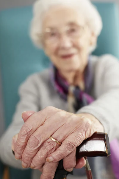 Äldre kvinna avkopplande i stol anläggning käpp — Stockfoto