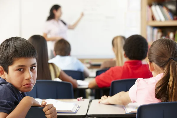 Unhappy schoolboy in class — Stock Photo, Image