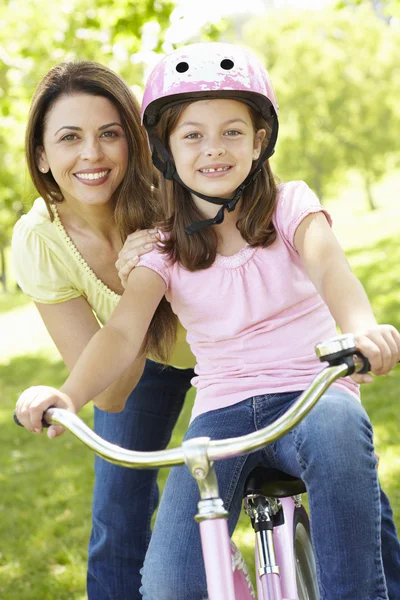 Девушка на велосипеде с матерью — стоковое фото