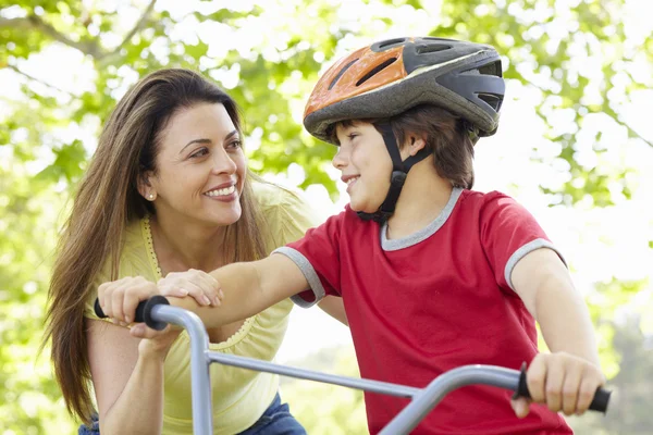 Мальчик на велосипеде с матерью — стоковое фото