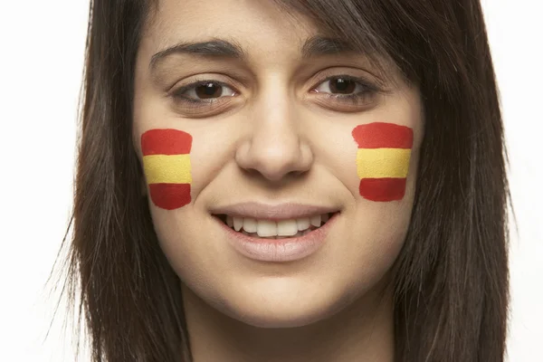 Ventilador deportivo femenino joven con bandera española pintada en la cara Fotos de stock
