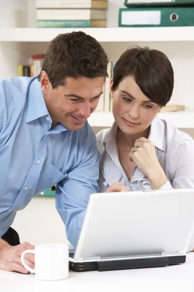 Couple Working From Home Using Laptop Stock Photo
