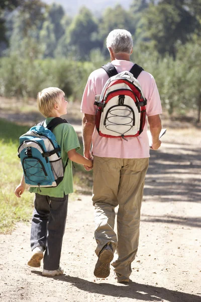 Senior man and grandson on country walk Royalty Free Stock Images
