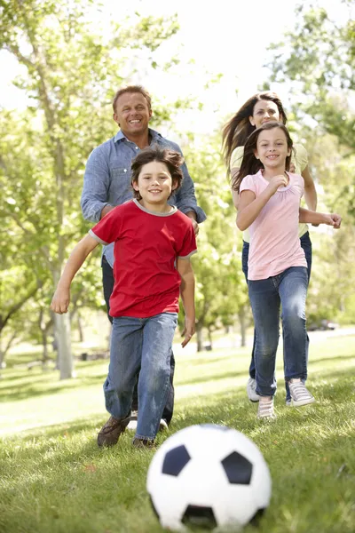 Family playing football in park Stock Picture
