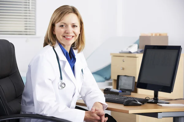 Portrait American doctor sitting at desk Royalty Free Stock Photos