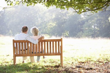 Senior couple sitting outdoors clipart