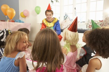 Young children eating jam tarts at birthday party clipart