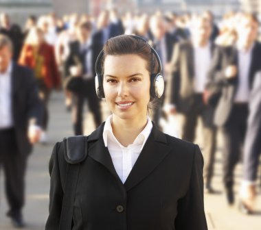 Female commuter in crowd wearing headphones clipart