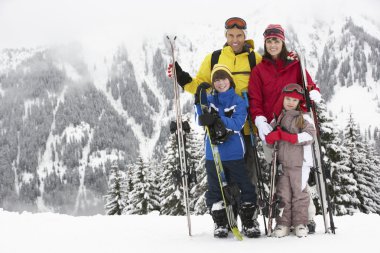 Family On Ski Holiday In Mountains clipart