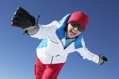 Woman Having Fun On Ski Holiday In Mountains clipart