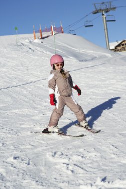 Young Girl Skiing Down Slope Whilst On Holiday In Mountains clipart