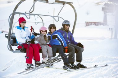 Family Getting Off chair Lift On Ski Holiday In Mountains clipart