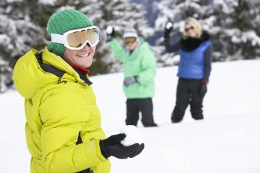 Group Of Young Friends Having Snowball Fight On Ski Holiday In M clipart