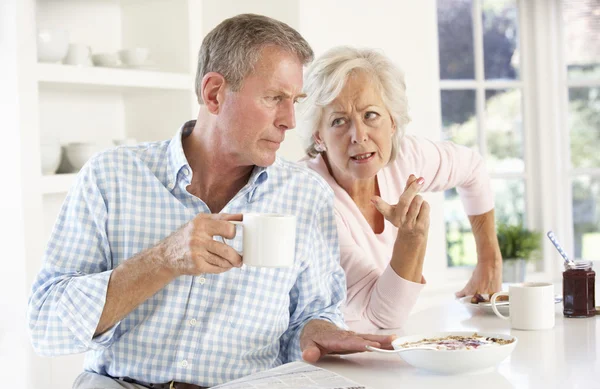 争论在吃早饭时对退休的夫妇 — 图库照片