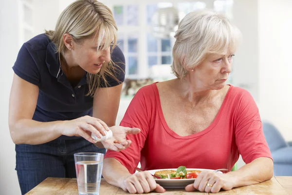 Äldre kvinna vägrar medicin hemma — Stockfoto