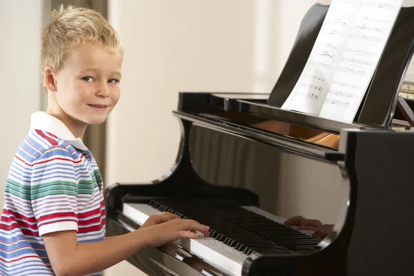 Мальчик играет на рояле дома — стоковое фото