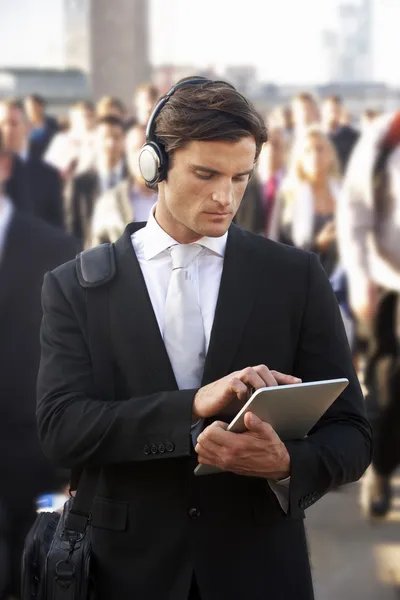 Comutador masculino na multidão com tablet e fones de ouvido — Fotografia de Stock