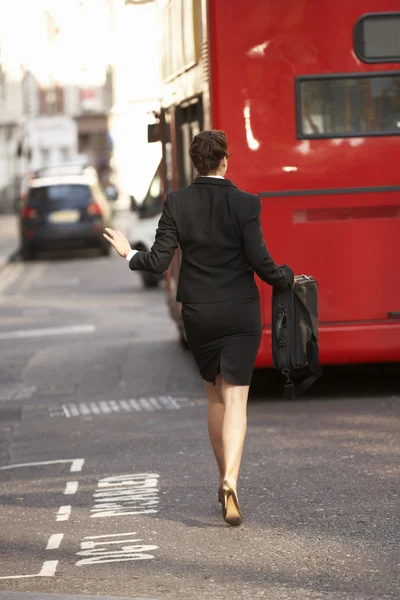 Businesswoman running for bus — Stock Photo, Image