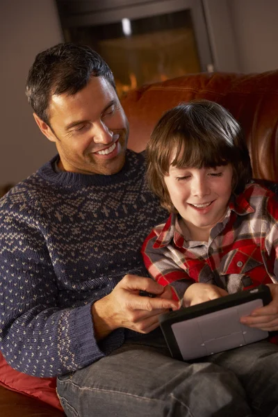 Baba ve oğul rahat günlük ateşin yanında tablet bilgisayar kullanma — Stok fotoğraf