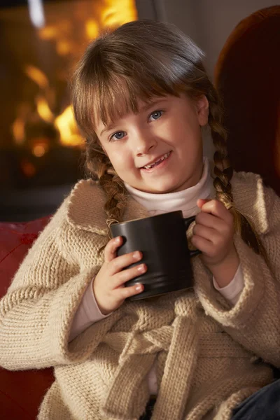 Giovane ragazza rilassante con bevanda calda da accogliente log fuoco — Foto Stock